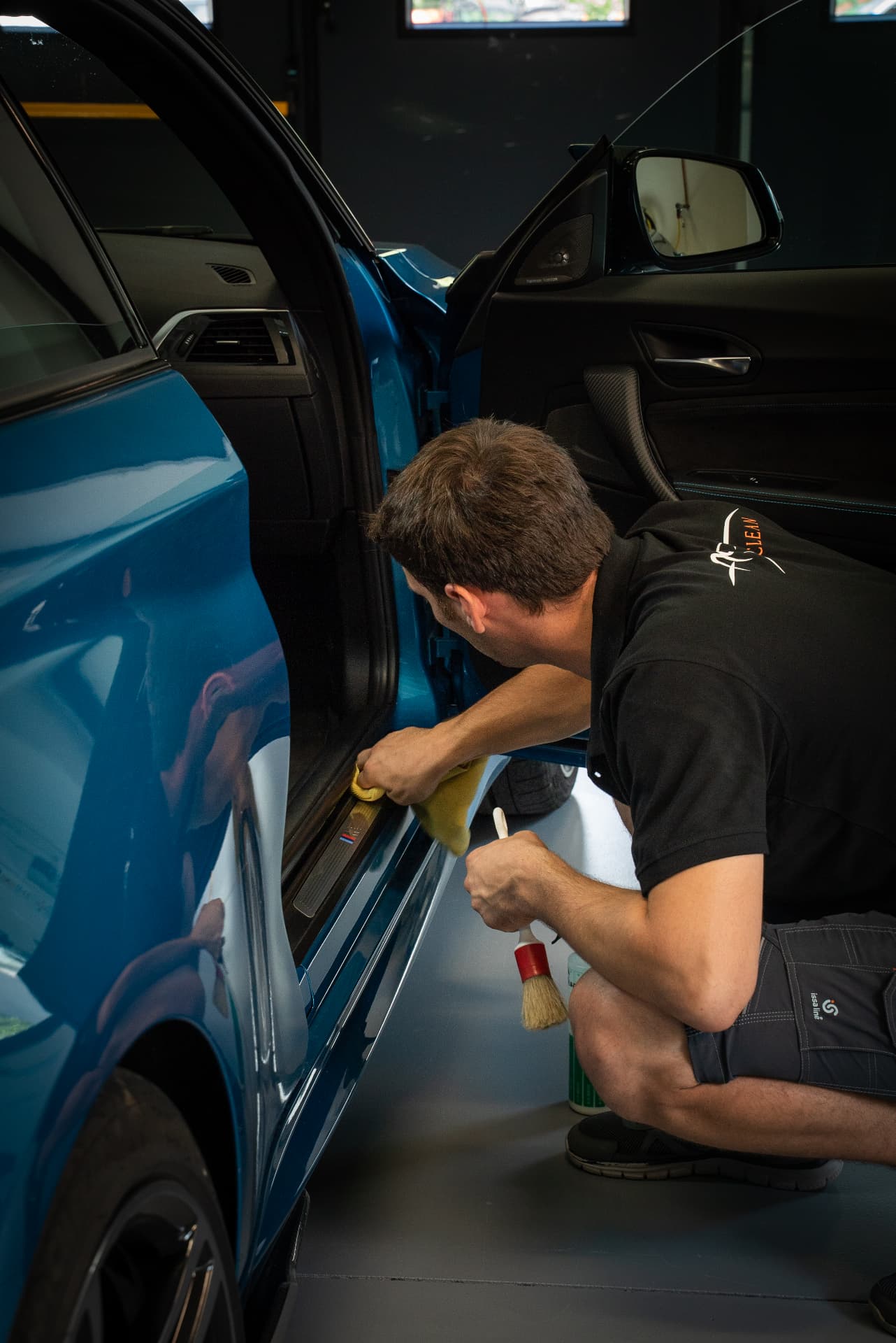 Pulizia al dettaglio del battitacco di una BMW blu